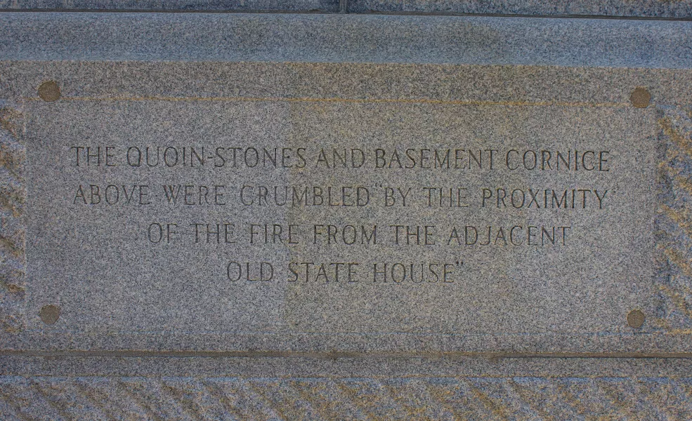 Inscription describing fire damage, 2019. Located on the northern elevation of the State House, this inscription replaced the original brass plaque.